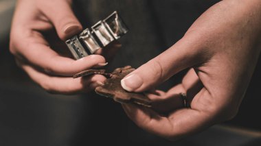 Kadın elleri kalıpları kullanarak ev yapımı Noel kurabiyeleri yapıyor.
