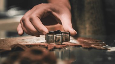 Kadın elleri kalıpları kullanarak ev yapımı Noel kurabiyeleri yapıyor.