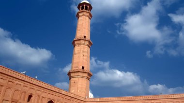 Arka planda bulutlu gökyüzü olan badshahi camii minaresi