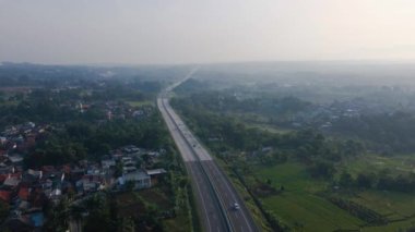 Sabahleyin sisli bir şekilde otobandan geçen araçların insansız hava aracı videosu, insansız hava aracı sabit bir konumda ve kamera ileriye bakıyor.