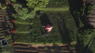 Uzakta insansız hava aracı videosu güzel bir dağ zeminli bir kamp çadırı var, İHA aşağı iniyor ve kamera aşağıya bakıyor.