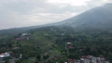 Birkaç evi olan bir tepenin insansız hava aracı videosu, insansız hava aracı ileriye bakıyor ve kamera ileriye bakıyor.