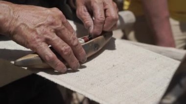 Hindistan 'ın Ladakh kentindeki eski bir antik ahşap dokuma tezgahını manipüle eden ellerin yakın çekimi.
