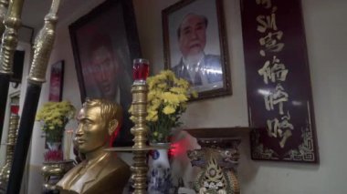 Geleneksel bir Vietnam Dövüş Sanatları sunağı. Altın bir heykel, portreler, mumlar, adaklar, atalara tapınma ve ruhaniliğin altını çizen bir sunak..