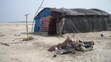 Ganj Nehri kıyısında, Varanasi, Hindistan 'da ölüm sonrası şenlik ateşiyle ağarlara tapanların çadırı 