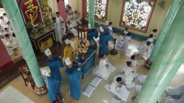 Vietnam dini Cao Dai. Renkli cüppeli keşişlerle birlikte tapınakta senkronize ritüeller gerçekleştiren kutsal bir tören.