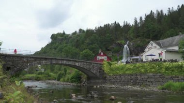 Arka planda Norveç köy köprüsü ve Majestic Steinsdalsfossen şelalesi