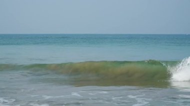 Çarpıcı turkuaz okyanus dalgaları kumlu bir tropik cennet sahiline çarpıyor. 