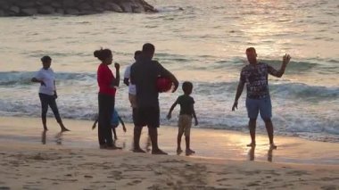 Sri Lanka ailesi günbatımının tadını çıkarın ve tropikal okyanus sahillerinde oynayın.
