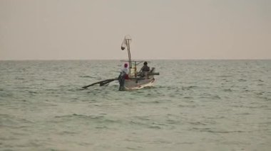 Sri Lanka okyanus sahilinde geleneksel bir teknede balıkçılar.