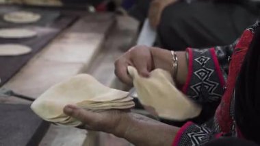Delhi Gurdwara Sikh Tapınağı 'nda kadın düz ekmek chapati katlıyor.