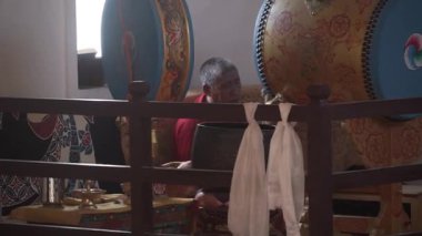Ladakh 'taki Budist keşiş ladakh manastırında büyük bir ritüel davulu çalıyor.