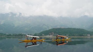 Srinagar, Hindistan - 10 Haziran 2018: Dal Gölü 'nde arka planda dağlarla birlikte iki tekne yüzüyor