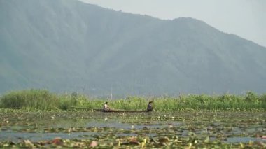 Srinagar, Hindistan - 10 Haziran 2018: Dal Gölü 'nün arka planında dağlar olan bir tekne