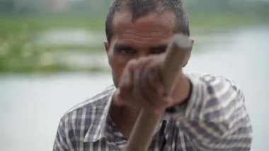 Srinagar, Hindistan - 10 Haziran 2018: Hintli bir adam Dal Gölü 'nde kareli bir gömlekle kürek çekiyor