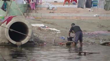 Zavallı Hintli adam sabahları Ganj Nehri 'nde çamaşır yıkıyor.