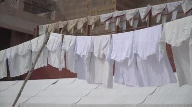 Beyaz temiz giysiler Ganges Nehir Kıyısındaki geçici çamaşırhanelerde asılı duruyor.