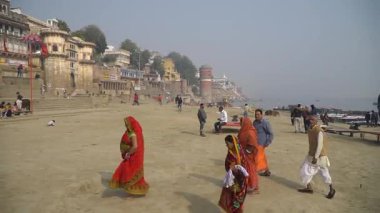 Güneşli bir günde Ganj Nehri 'nin kıyısında Varanasi Ghat' ları boyunca yürümek