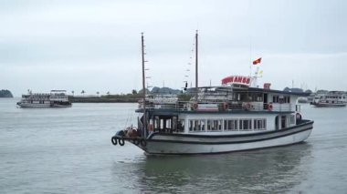  HaLong Bay 'de bulutlu gökyüzünün altında bir tekne gezisi yaşayın.