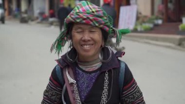 Geleneksel giyinmiş bir kadın Vietnam 'da Sa Pa caddesinde gülümsüyor.