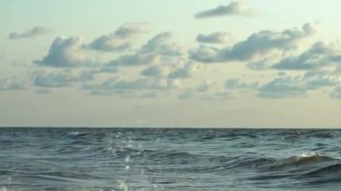 Gün batımında Baltık Denizi üzerindeki yumuşak dalgaları ve geniş gökyüzünü keşfediyorlar.