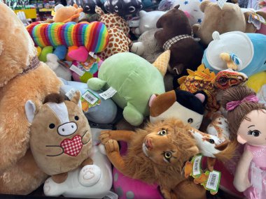 Bir mağazada sergilenen canlı pelüş oyuncaklar, aslan, at ve zürafa gibi hayvanların yer aldığı renkli tasarımlar, neşeli ve neşeli bir atmosfer yakalıyor..