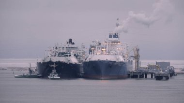 Gemiler arası operasyonlar sırasında limanda yüzen depolama ve yeniden gazlandırma ünitesi ve sıvılaştırılmış doğalgaz taşıyıcısı