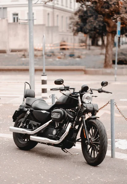 stock image A black modern motorcycle is parked on the street next to a pedestrian cross. Prohibited parking of the vehicles. Parking violations.