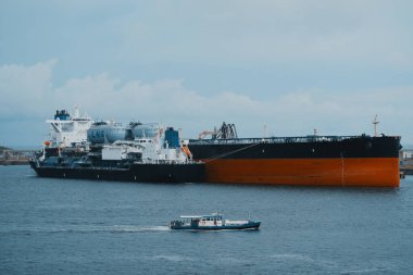 Yüzen depolama ve yeniden gazlandırma ünitesi. Sıvılaştırılmış doğalgaz depolama gemisi ve limanda LNG tarafından desteklenen petrol tankeri..