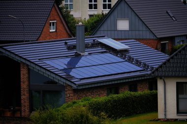 Kiel, Almanya - 07: 30 2023: çatıda güneş panelleri olan ev. Doğa tarafından üretilen enerji. Güneş enerjisi üretiyor. Kırsaldaki ahır evinin fotovoltaik sistemleri. Yenilenebilir enerji kavramı