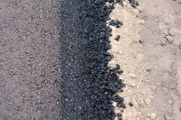Freshly paved road in the European countryside. Road construction and maintenance works. Brand new asphalt on the road.