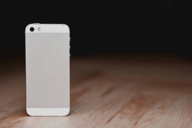 Ahşap zeminde sensör ekranı olan antika telefonun bir kopyası. Telefonun arka görüntüsü.