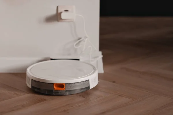 Smart home technology. Concept of efficient house cleaning. Autonomous vacuum cleaner and charging station.