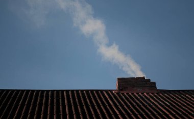 Bacadan duman çıkıyor. Kömürle ısıtılıyor. Dışarısı serin. Odunla evin ısıtılması.. 