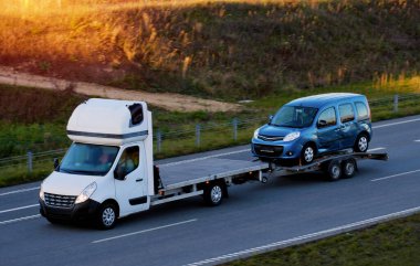 Trafik kazası geçirdikten sonra hasarlı bir ticari araçla çekilen aracın yan görüntüsü. Acil yol yardımı..