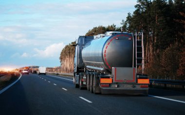 Petrol kargo kamyonu otobanda petrol nakliyesi yapıyor. Yakıt teslimatı ve lojistik konsepti. Bir otoyolda sıkıştırılmış gaz kamyonu dikiz aynası. Tehlikeli mallar toplu olarak naklediliyor.