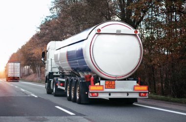 Petrol kargo kamyonu otobanda petrol nakliyesi yapıyor. Yakıt teslimatı ve lojistik konsepti. Bir otoyolda sıkıştırılmış gaz kamyonu dikiz aynası. Tehlikeli mallar toplu olarak naklediliyor.