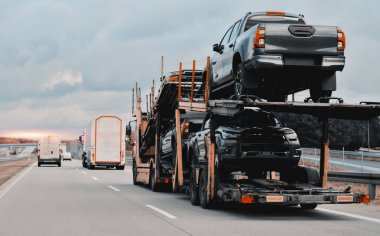 Satılık yepyeni SUV arabaları olan bir karavan kamyonu. Yeni araba teslimatı ve nakliyat. Araba taşıyıcı karavanı müşteriler için bir sürü yeni arabayla dolu. İki seviyeli modüler hidrolik yarı römork.