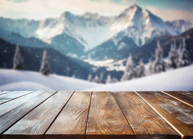 Bulanık Bokeh arka planında karla kaplı Rocky Dağları 'nın olduğu tahta masa masasının tepesine seçici bir odaklanma. Noel Ruhu Görselleştirme ve Sunum.