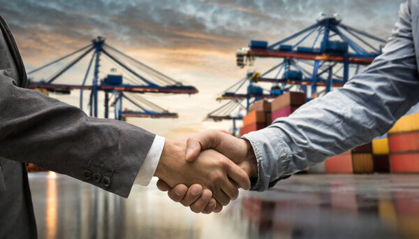 Handshake Deal In Front Of The Container Shipping Terminal. Partnership Cooperation Between Two Companies. Investment Into the Shipping And Logistics Industry.