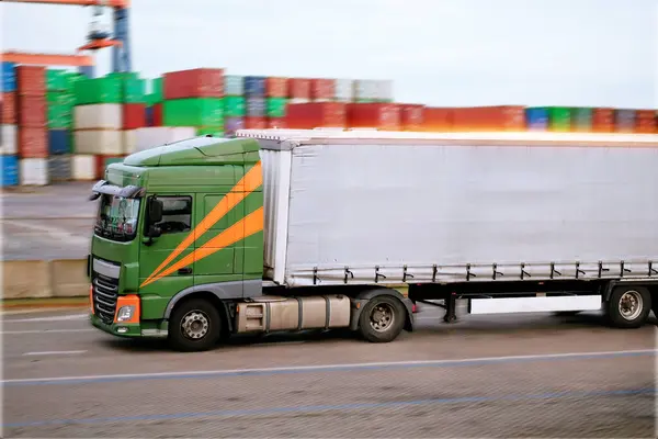 Camión de carga en el camino en movimiento de alta velocidad. Logística