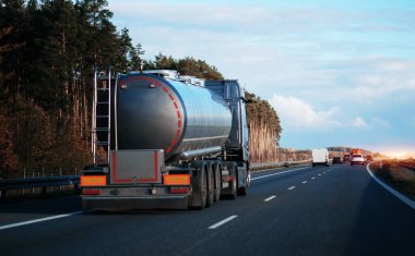 Otoyolda petrol kamyonu fosil petrol rafinerisi ürünleri taşıyor. Yakıt teslimatı. Havacılık yakıtı taşımacılığı. Bir otoyolda sıkıştırılmış gaz kamyonu dikiz aynası. Süt ürünleri taşıyıcısı