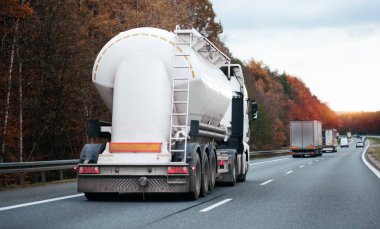 Otoyolda petrol kamyonu fosil petrol rafinerisi ürünleri taşıyor. Yakıt teslimatı. Havacılık yakıtı taşımacılığı. Bir otoyolda sıkıştırılmış gaz kamyonu dikiz aynası. Süt ürünleri taşıyıcısı