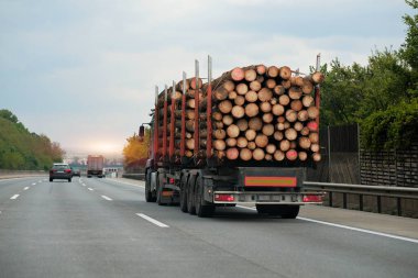 Otobanda ahşap kütüklerle dolu uzun bir karavan.