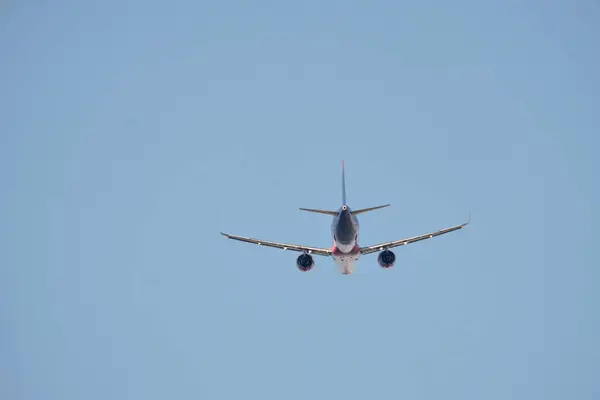 Stock image Airplane in Flight Viewed from Behind Against Clear Sky