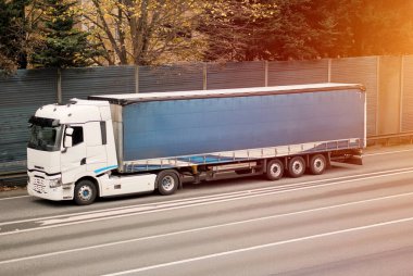 Teslimat güzergahında mavi brandalı ticari nakliye kamyonu