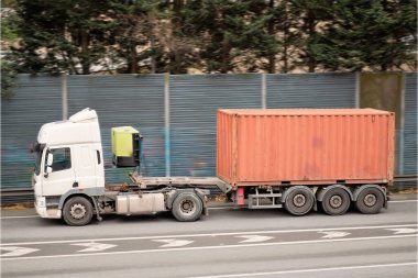 Truck Hauling Shipping Container on Highway clipart