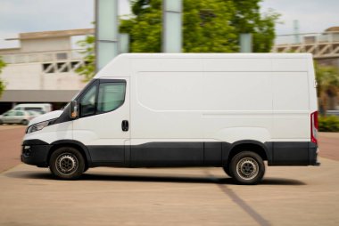 Long Wheelbase Beyaz Teslimat Minibüsü İş Bölgesi 'nden geçiyor.