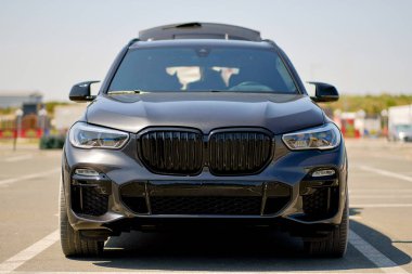 Şatafatlı Siyah SUV 'un Şehir Otoparkında Saldırgan Styling ve Parlak Izgaralı Önü