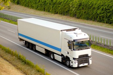 Beyaz Modern Sürdürülebilir Soğutma Taşıyıcısı, Hızlı Taşımacılık Konsepti Ormanı Yakınındaki Otoyolda Euro Semi Truck